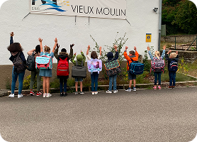 Les enfants devant le logo du vieux moulin